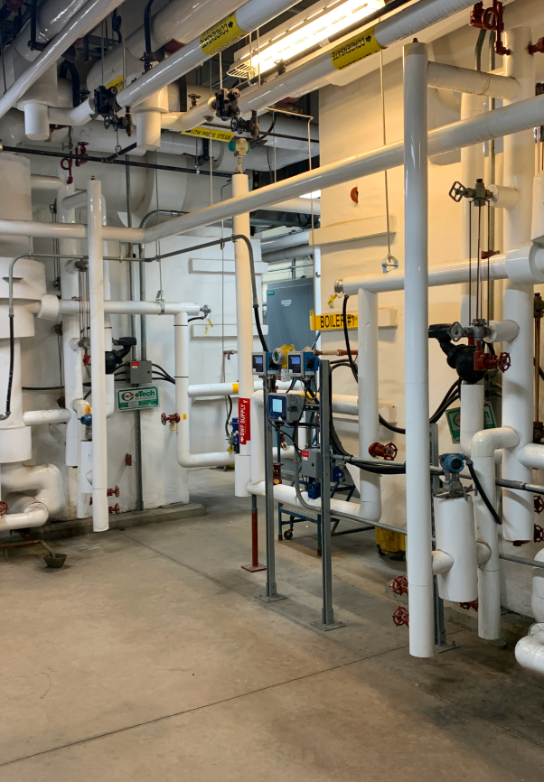 A yellow light bulb is hanging from a wire against a blue sky