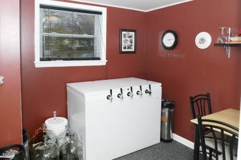Orange-colored drink in a branded glass with orange slices as garnish, outdoors on a sunny day.