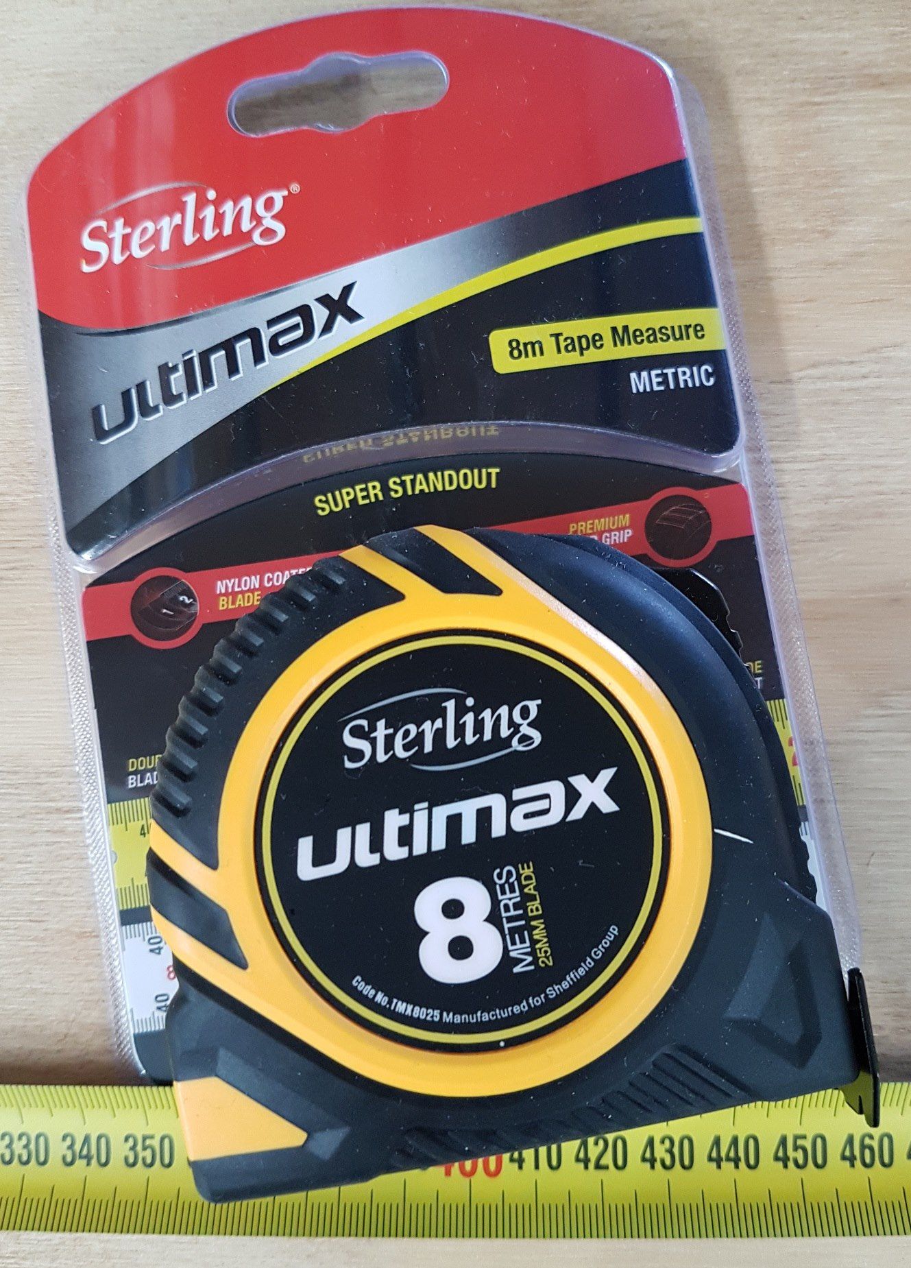 A sterling ultimax tape measure is sitting on a wooden table