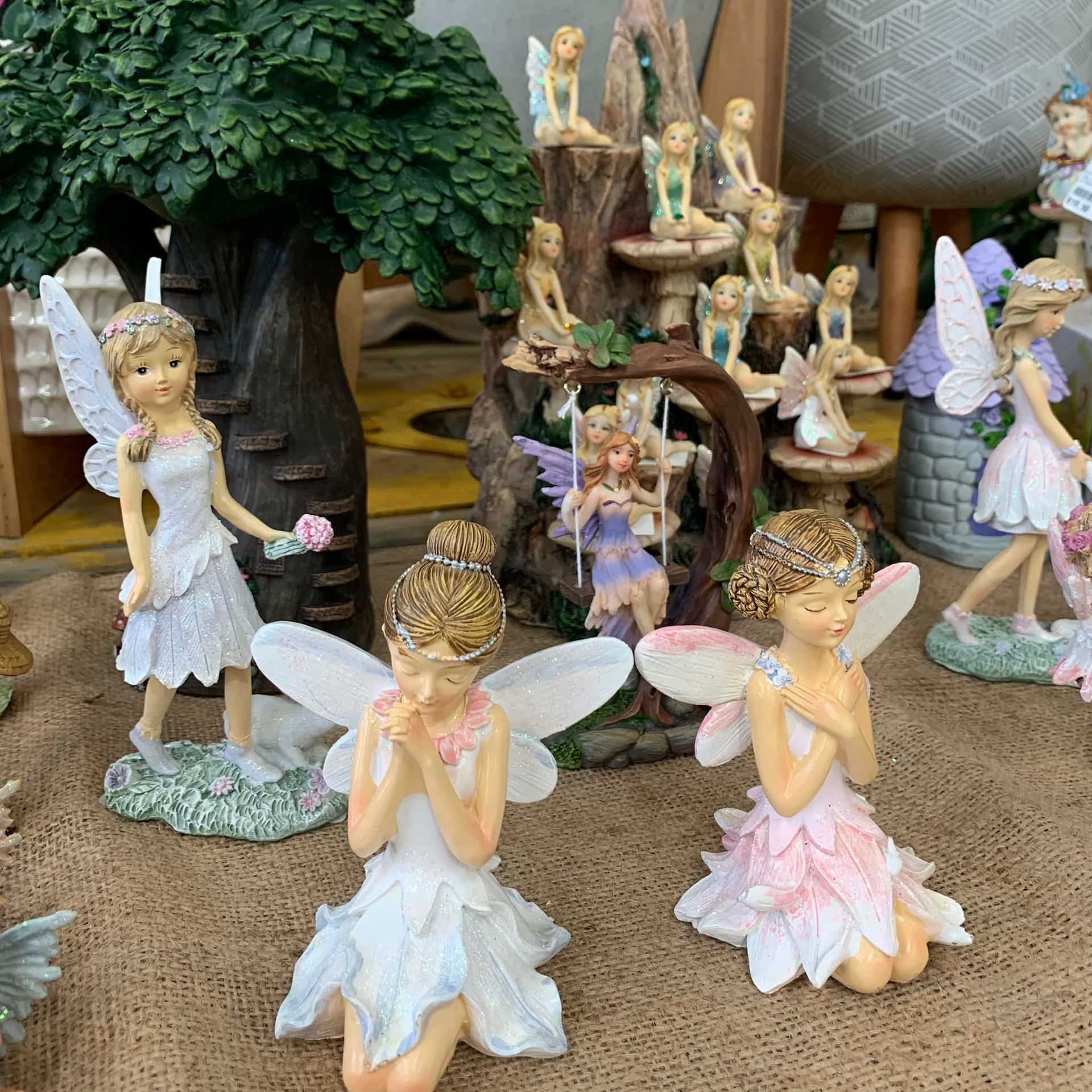 A group of fairy figurines are sitting on a table.