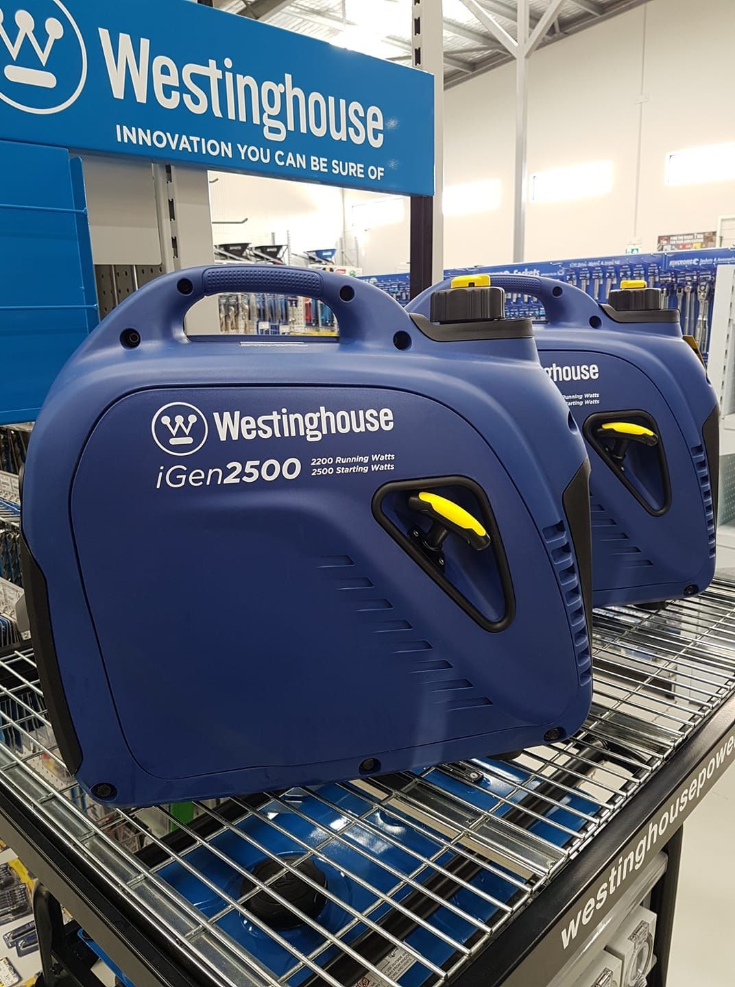 Two westinghouse generators are sitting on a shelf in a store.