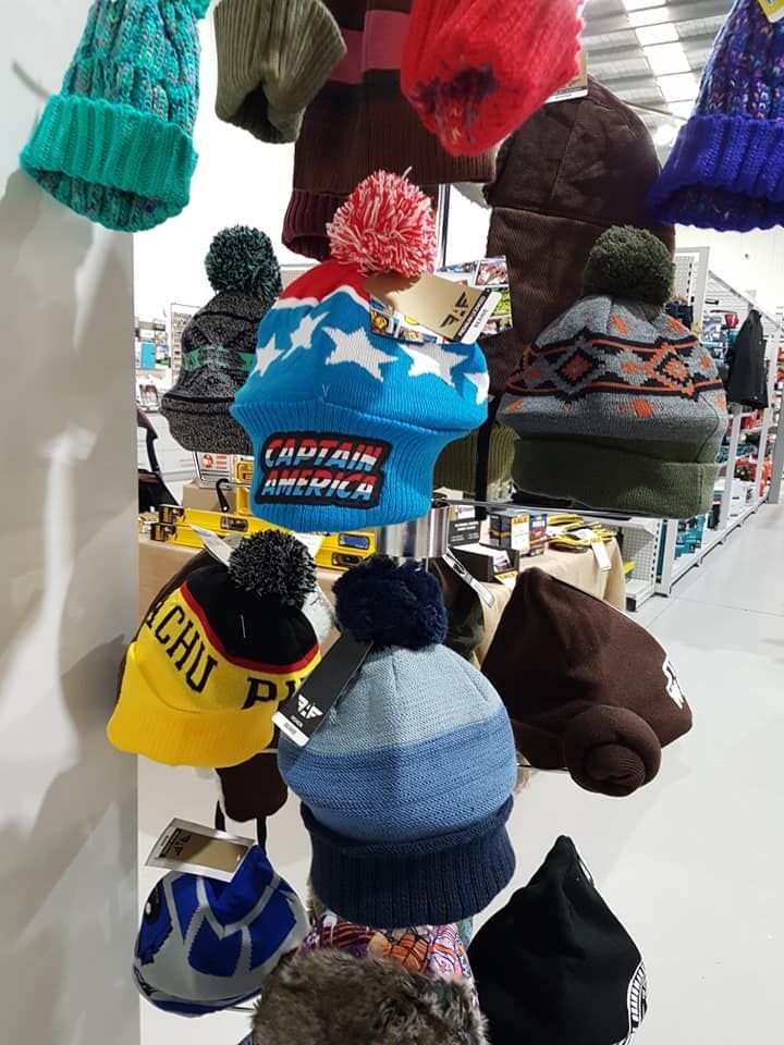 A bunch of hats are hanging on a rack in a store