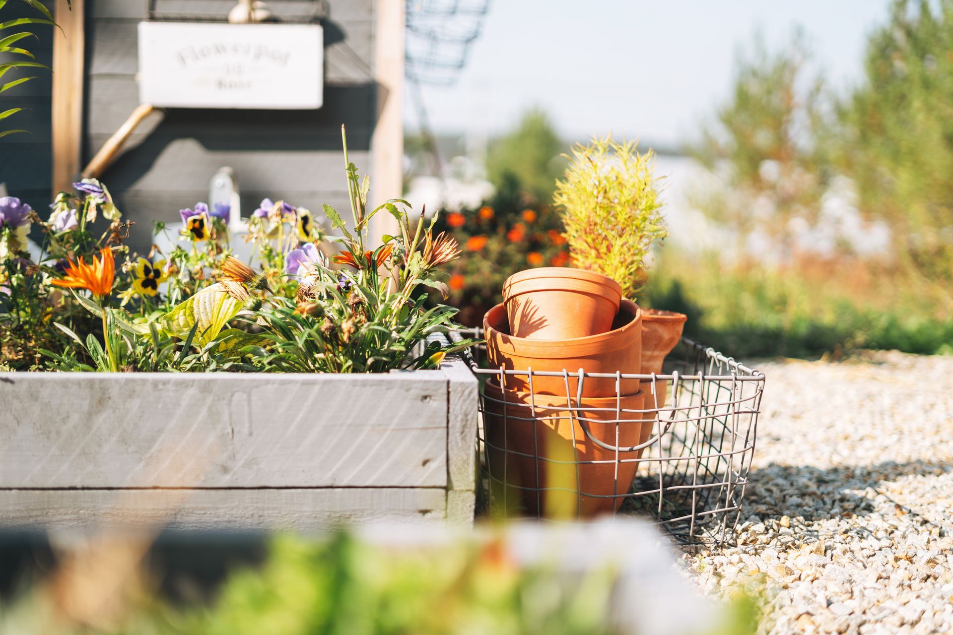 A wooden box filled with flowers and potted plants.