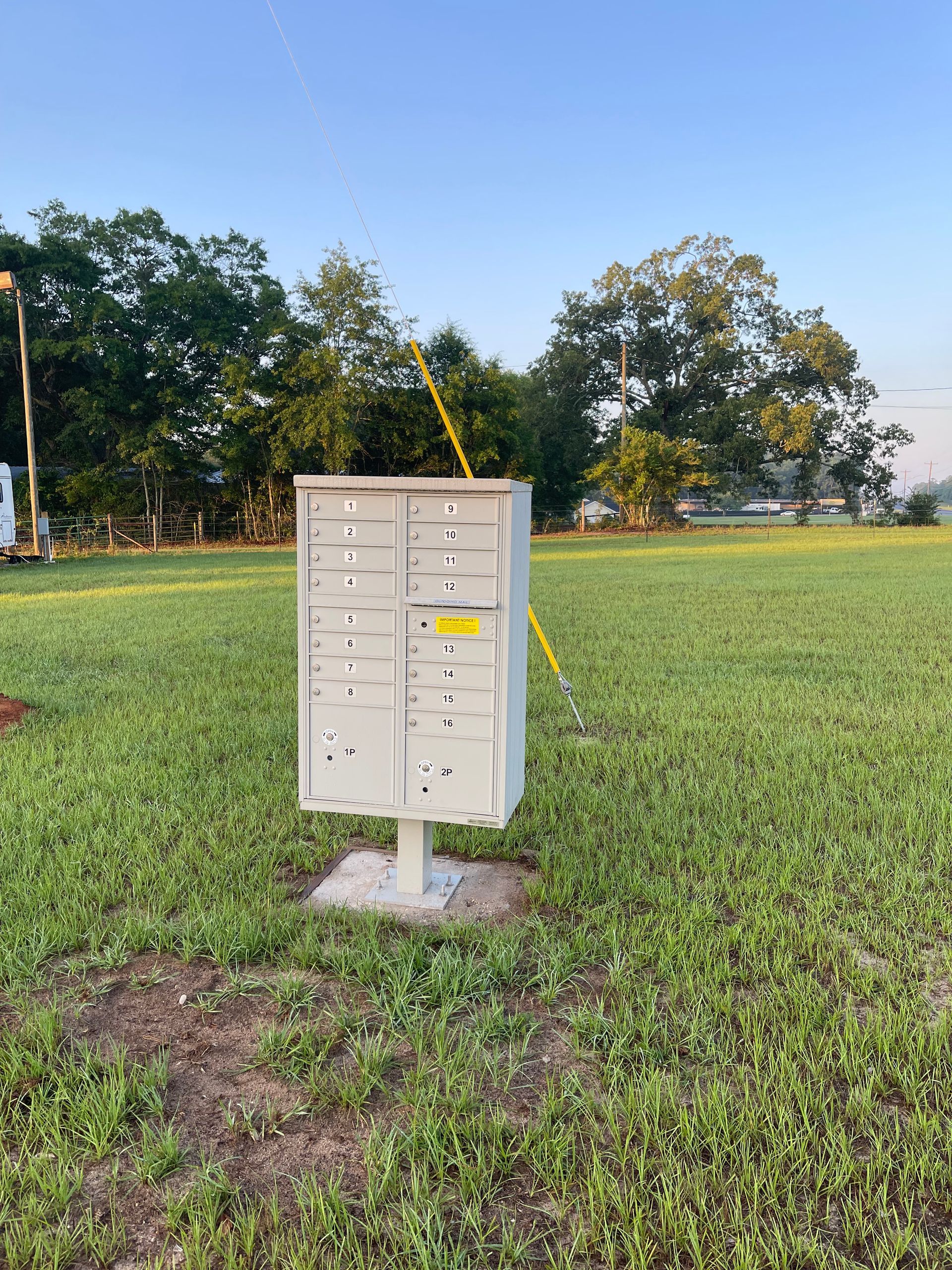 A mailbox is sitting in the middle of a grassy field.