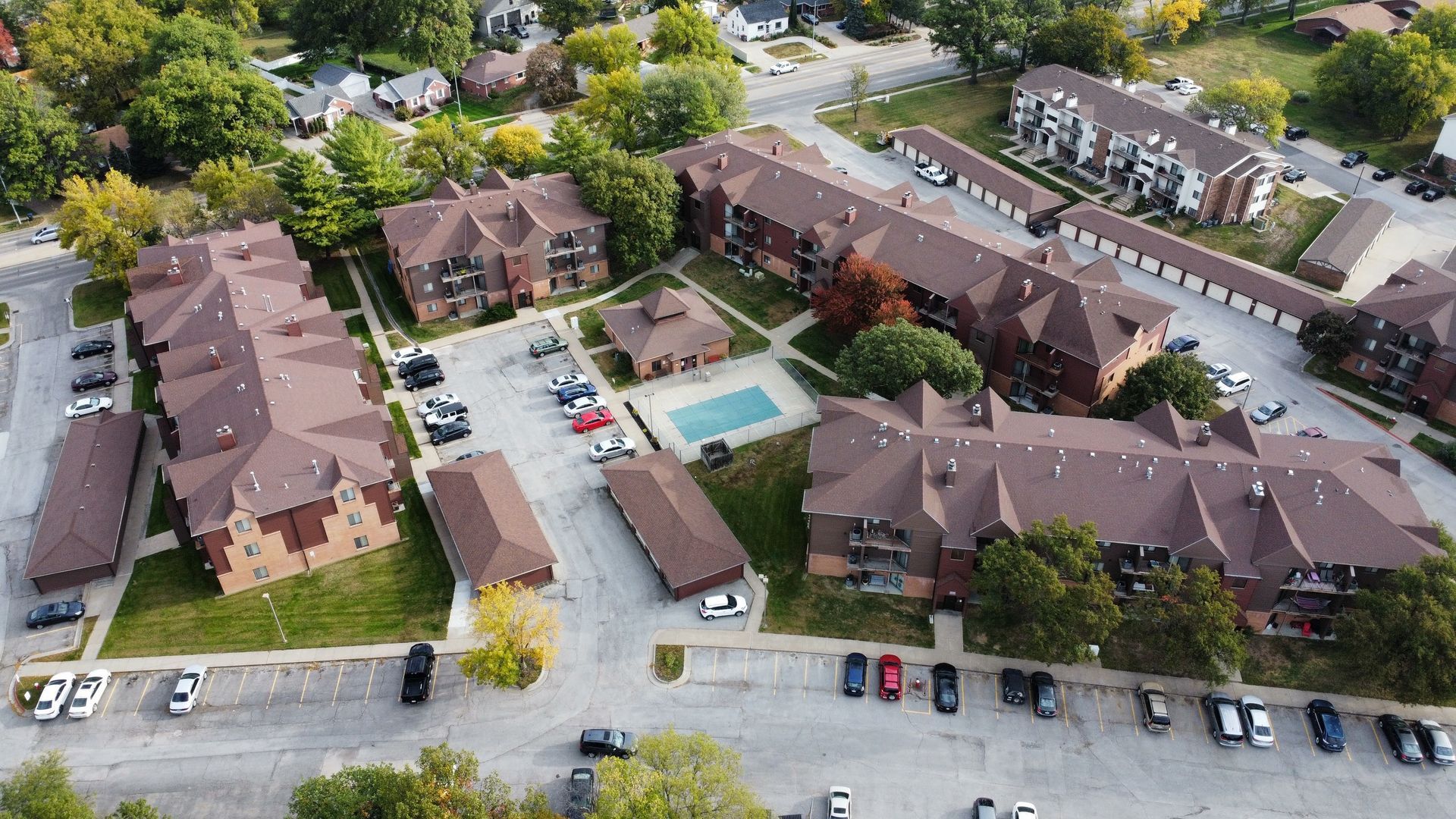 An aerial view of a large apartment complex with a pool in the middle.