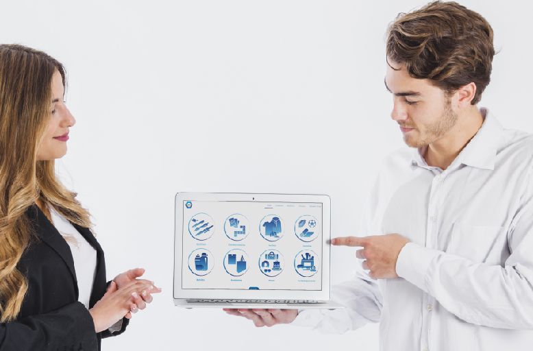 A man and a woman are looking at a laptop computer.