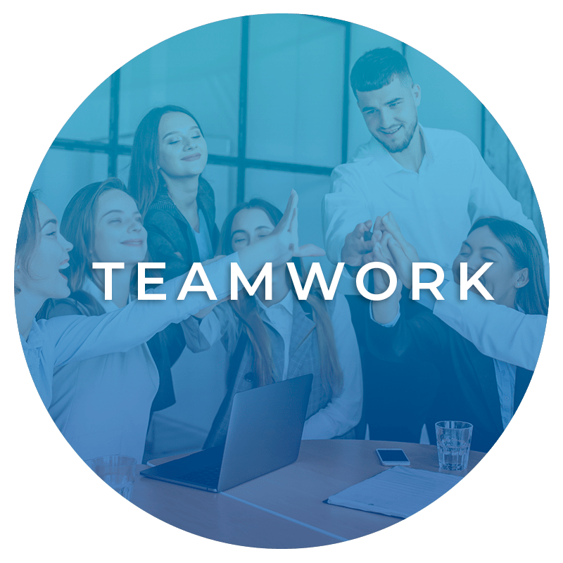 A group of people are giving each other a high five while sitting around a table with laptops.