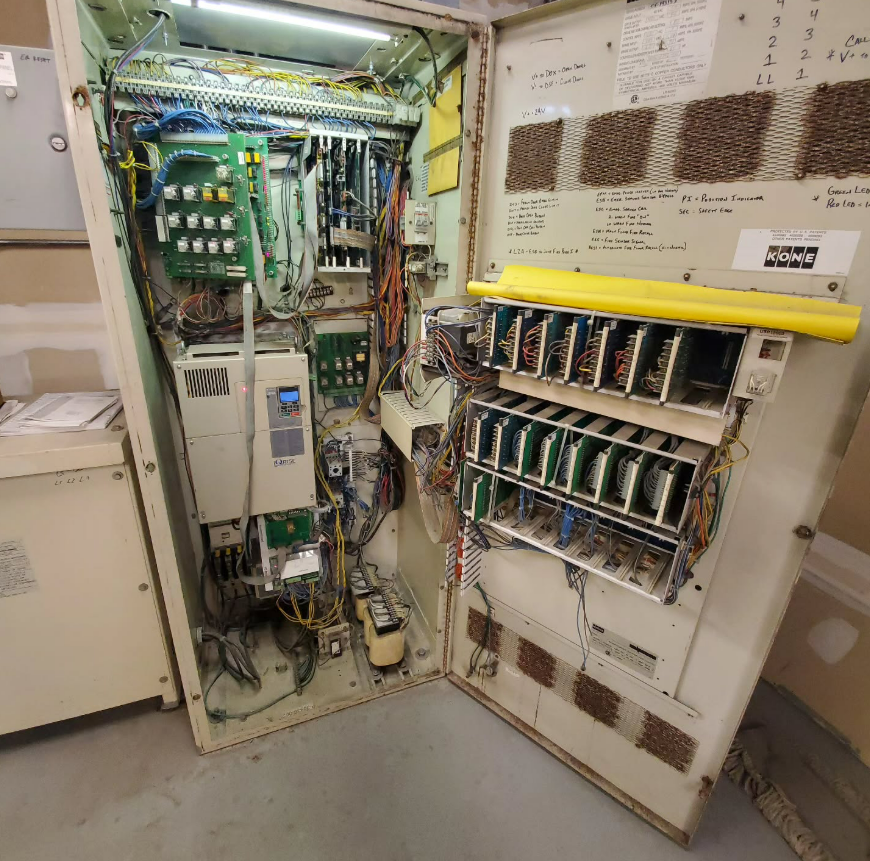 Open electrical control cabinet with various circuit boards, wiring, and components.