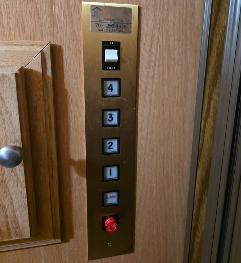 Elevator control panel with buttons for floors 1-4, a white on/off switch, and a red emergency button.