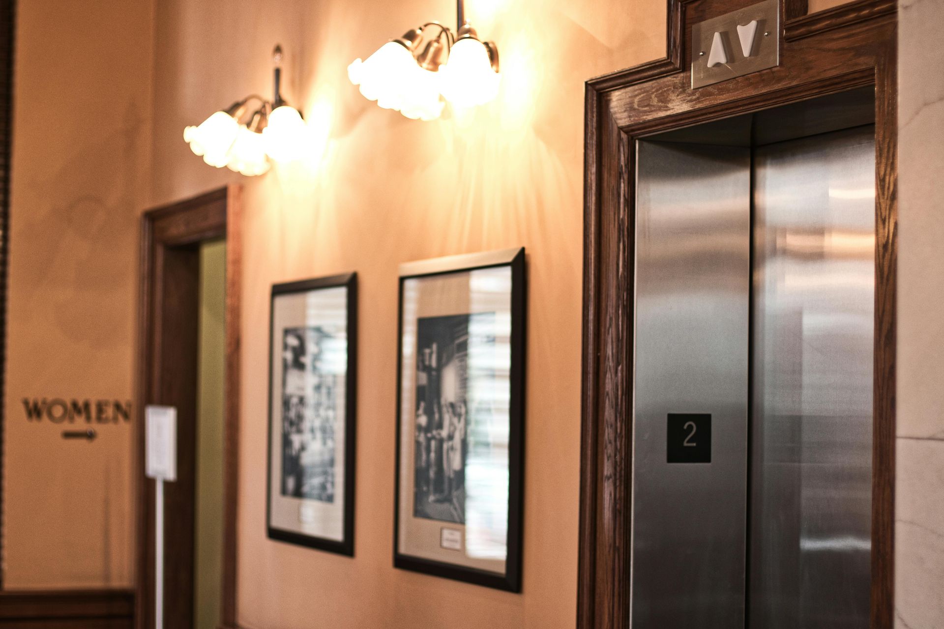 Hallway with elevator and framed pictures. 
