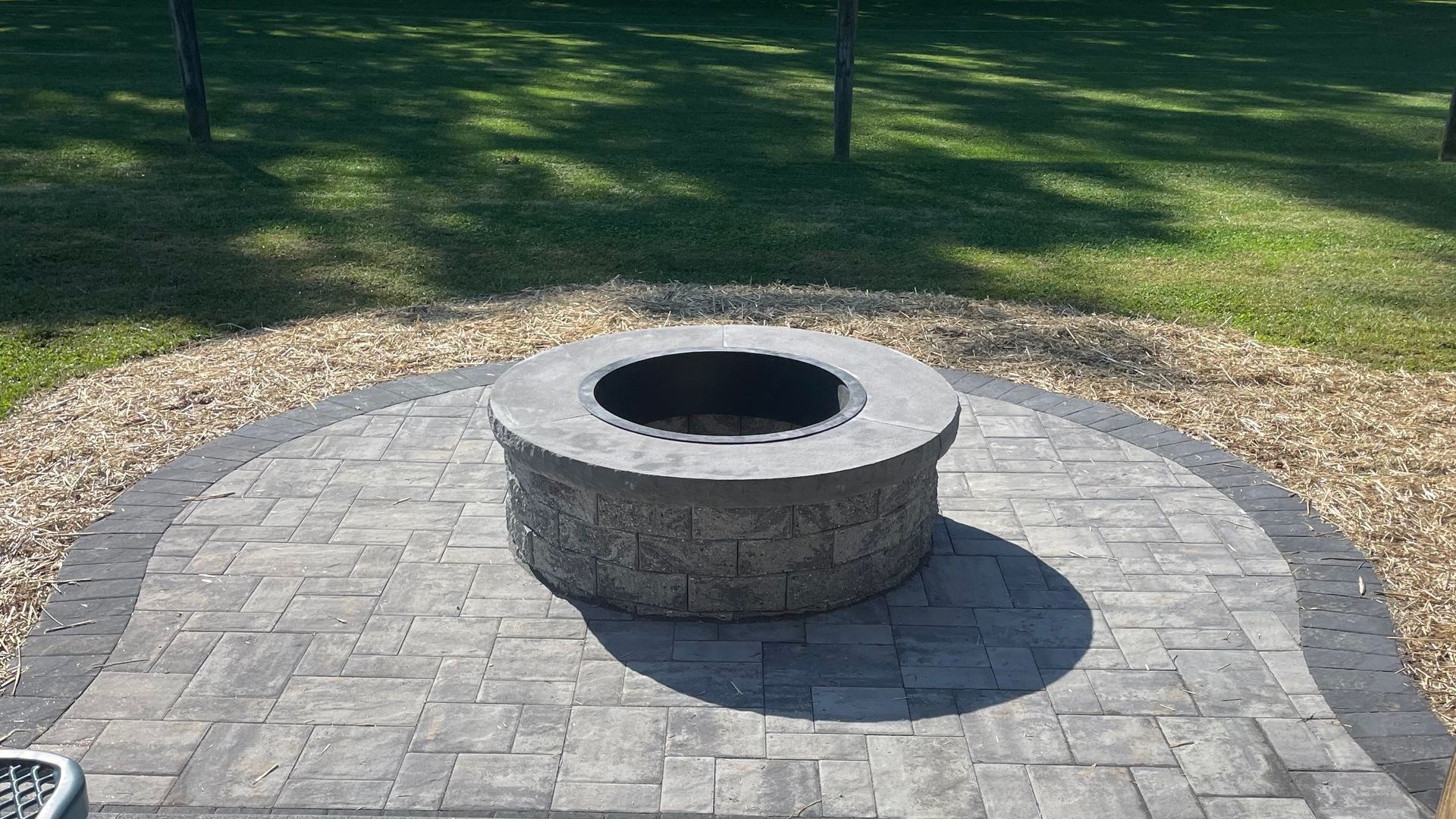 A fire pit is sitting on top of a brick patio.