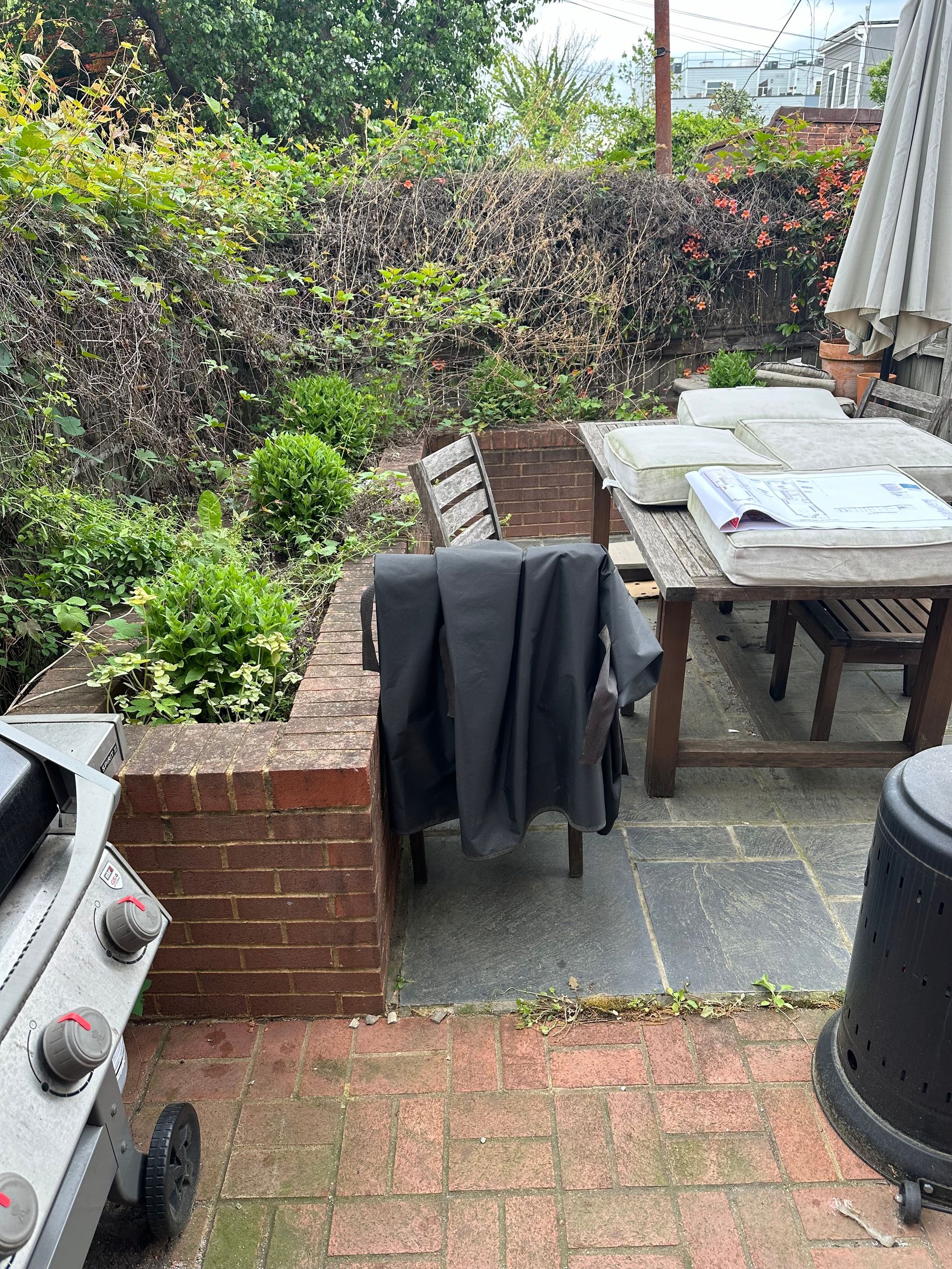 A patio with a table and chairs and a grill.
