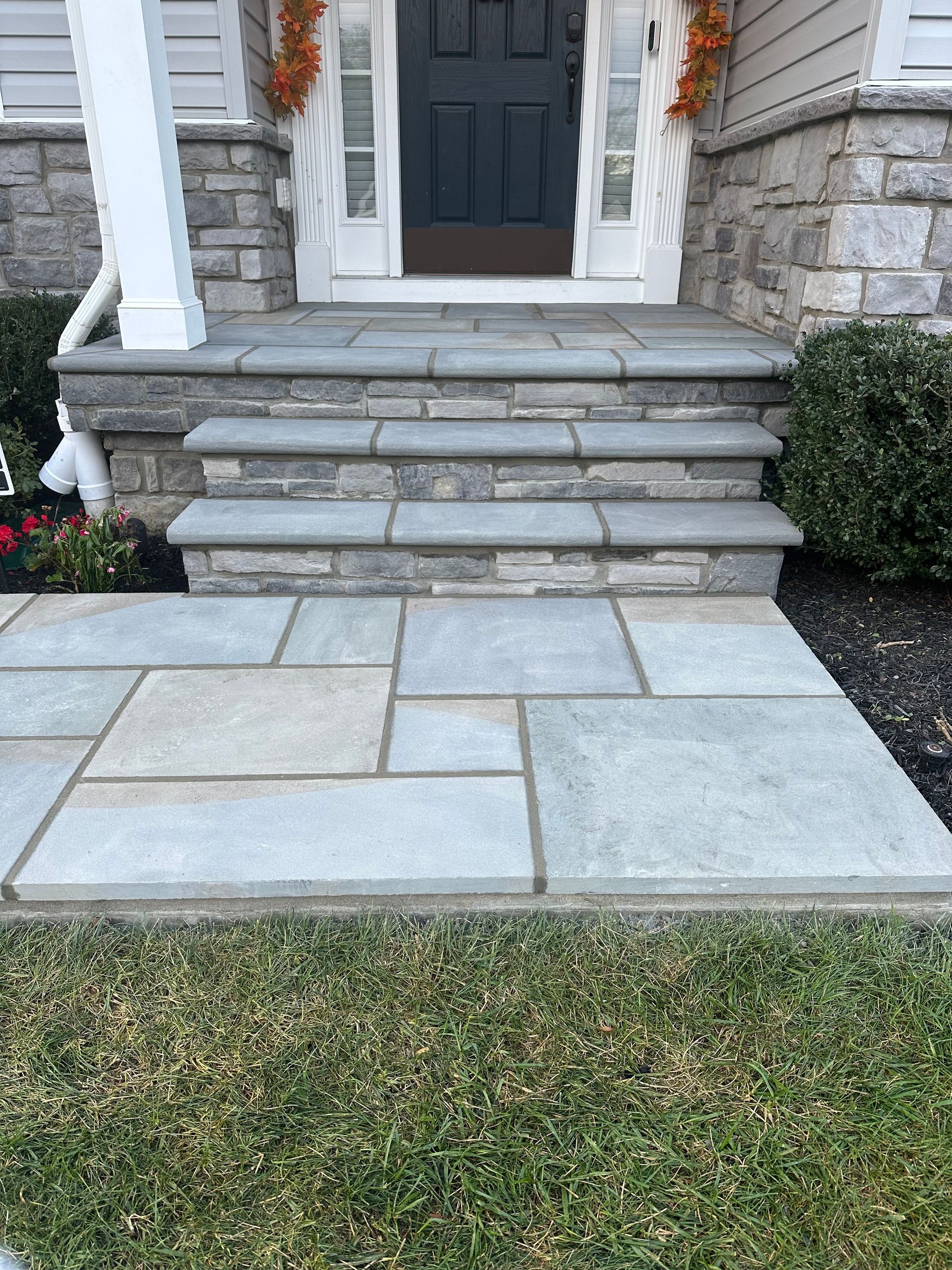 A stone walkway leading to the front door of a house.