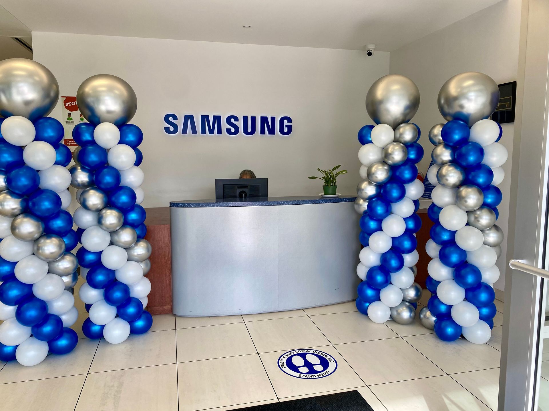 A samsung store is decorated with blue and silver balloons