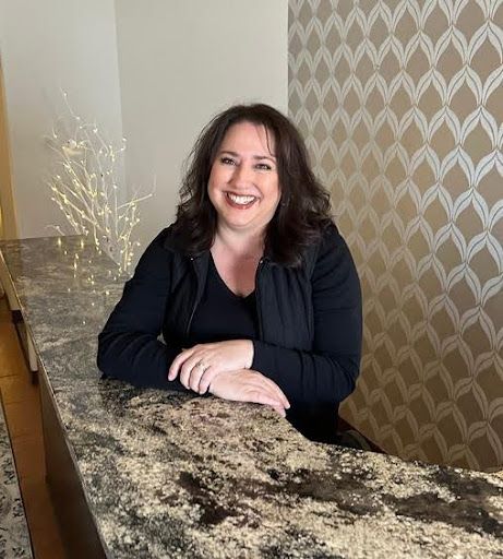 A woman is sitting at a counter and smiling.