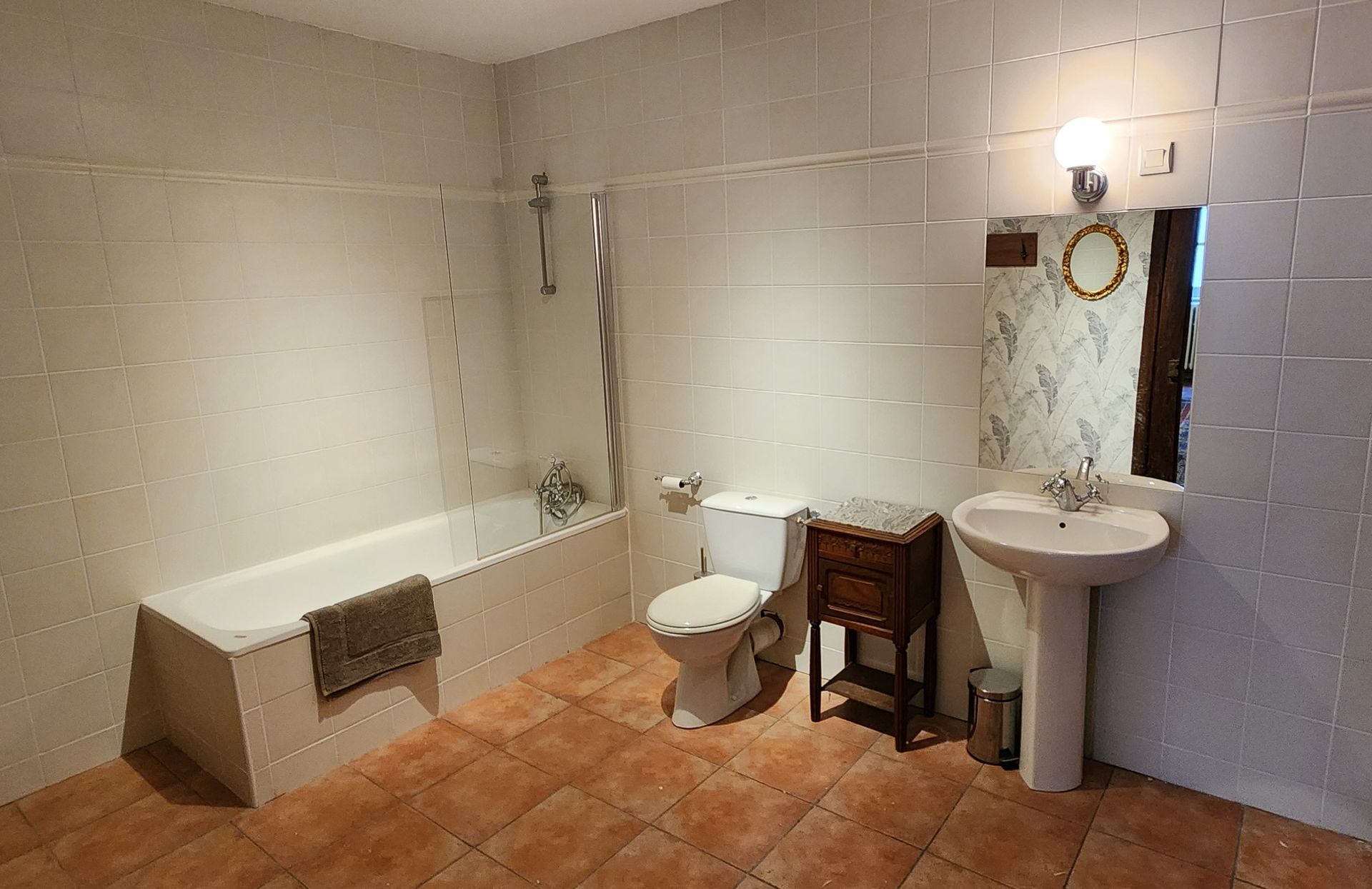 une salle de bain avec lavabo, toilettes, baignoire et miroir.