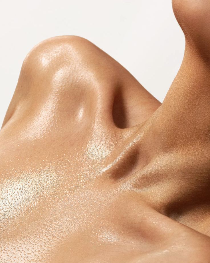 Close-up of a person's upper chest, collarbone, and neck; skin is smooth and shiny.