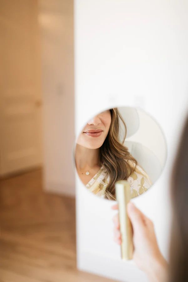 Treatment room with a white bed, decorative plants, and a bright task lamp.