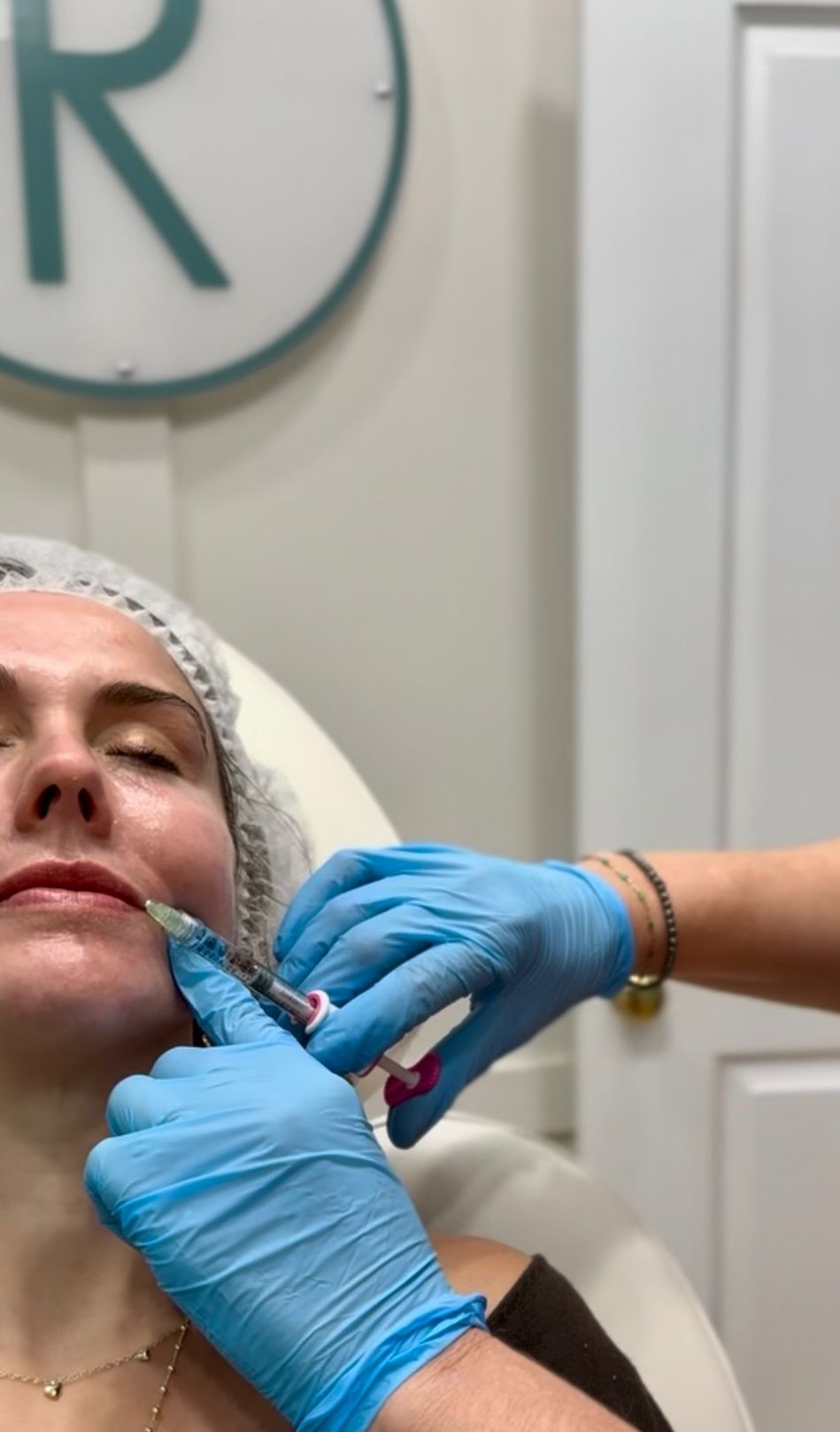 Person receiving cosmetic injections in a medical setting.