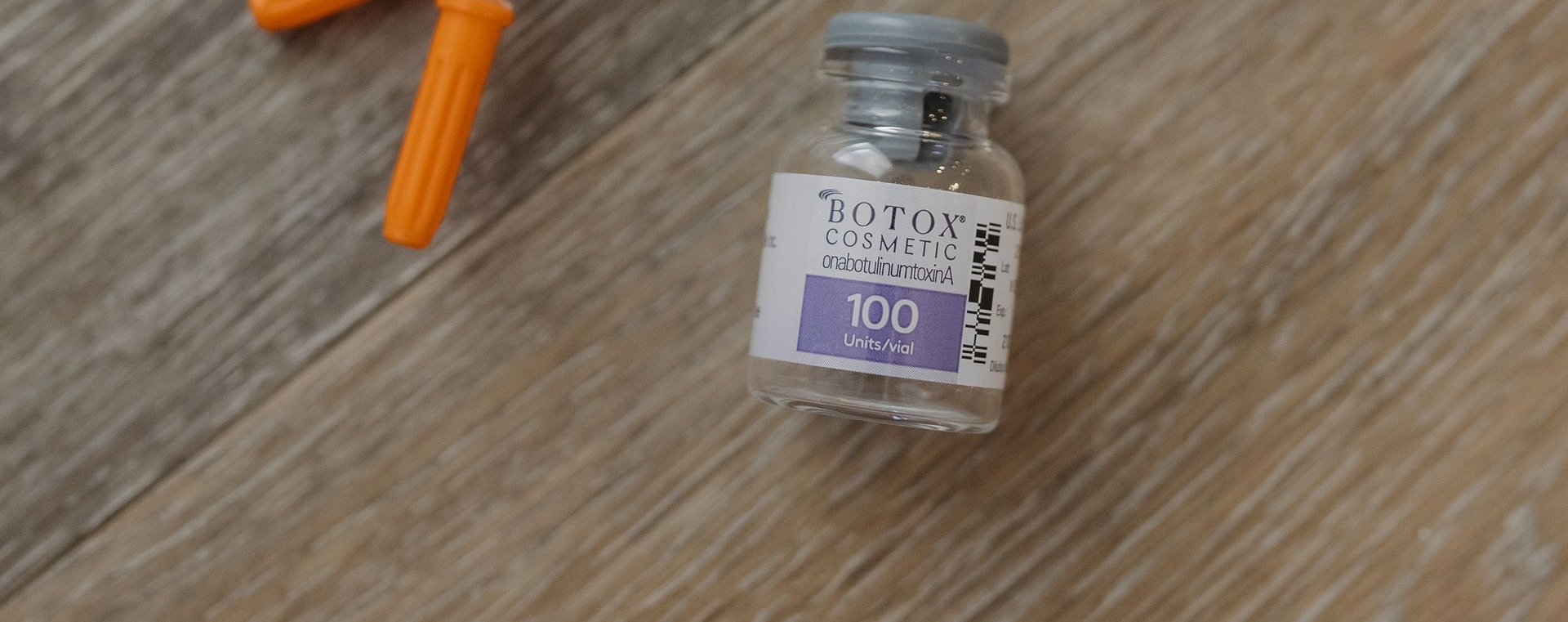 A person with a white towel wrapped around their head and wearing a white robe, gently touching their face in a mirror.