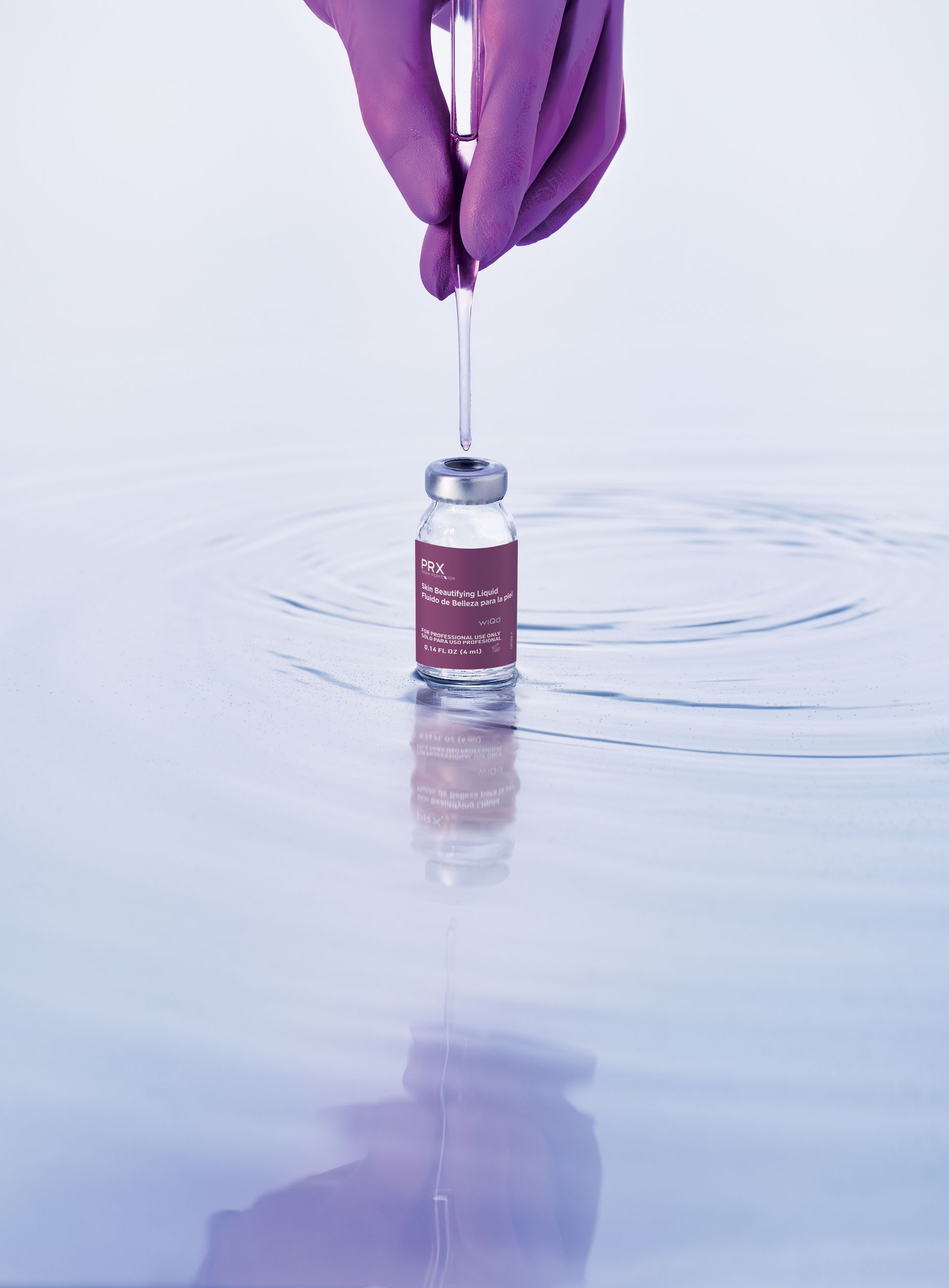 Gloved hand with syringe above a vial in liquid, likely a lab setting.