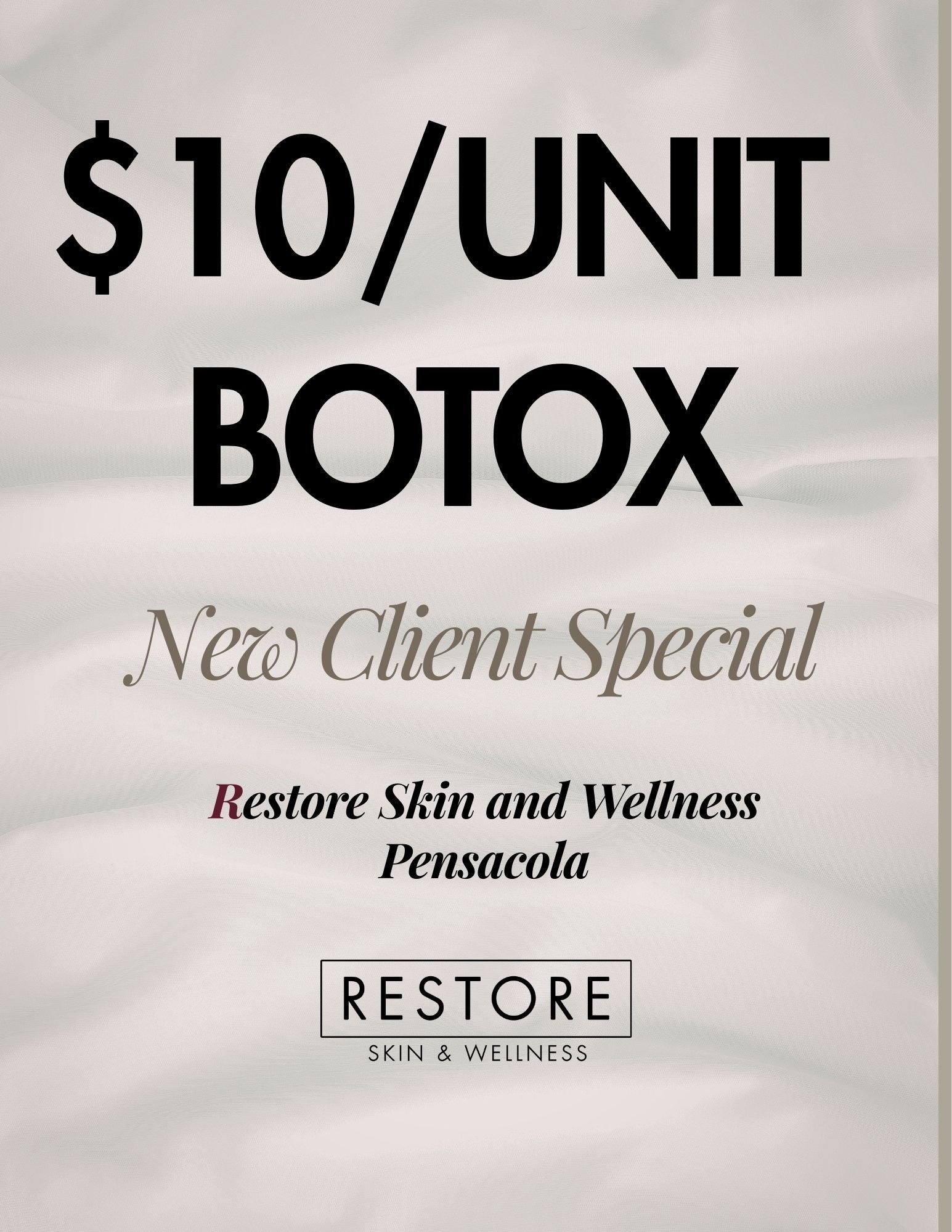 Woman with gray hair smiles, touching her face near the eyes in a bathroom.