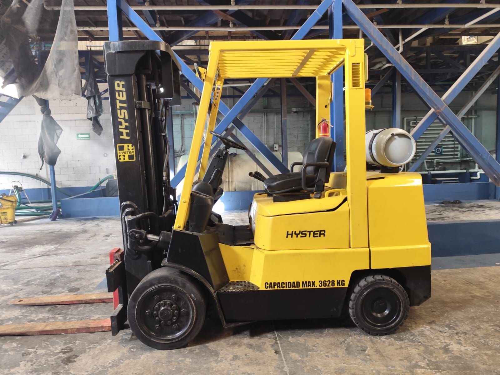 Una carretilla elevadora Hyster amarilla está estacionada en un almacén.
