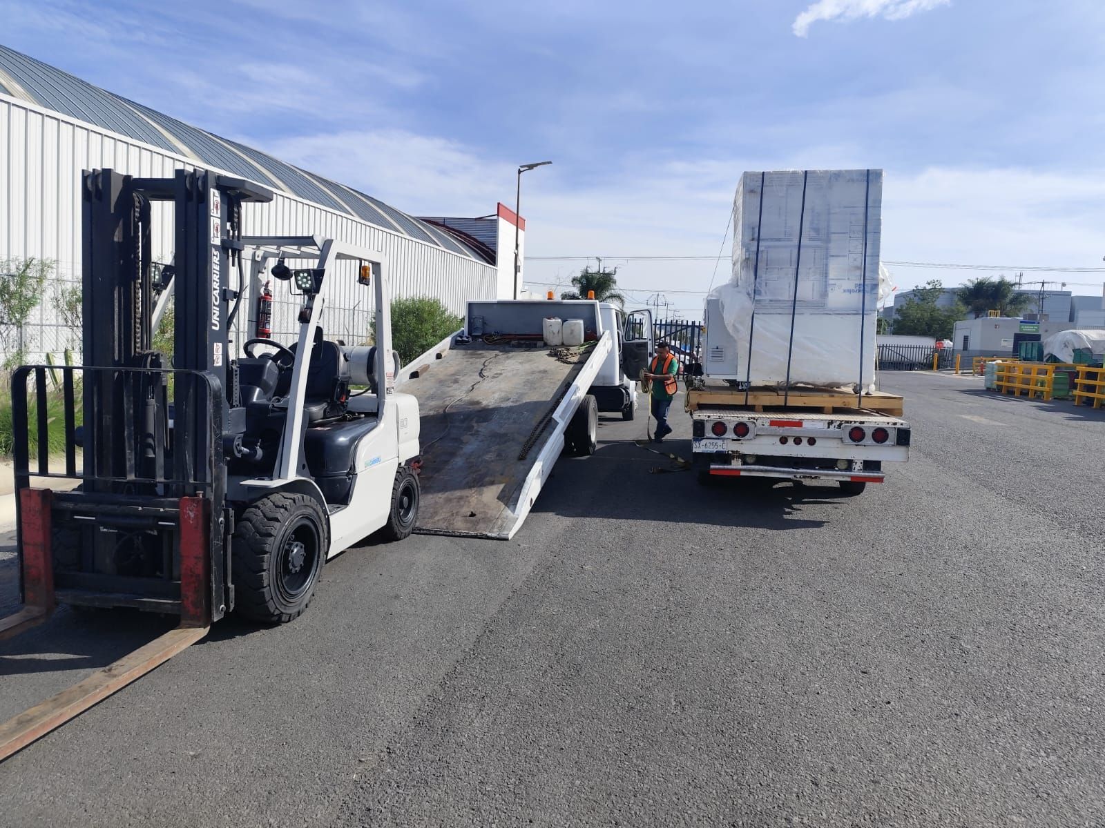 Una carretilla elevadora está siendo remolcada por una grúa.