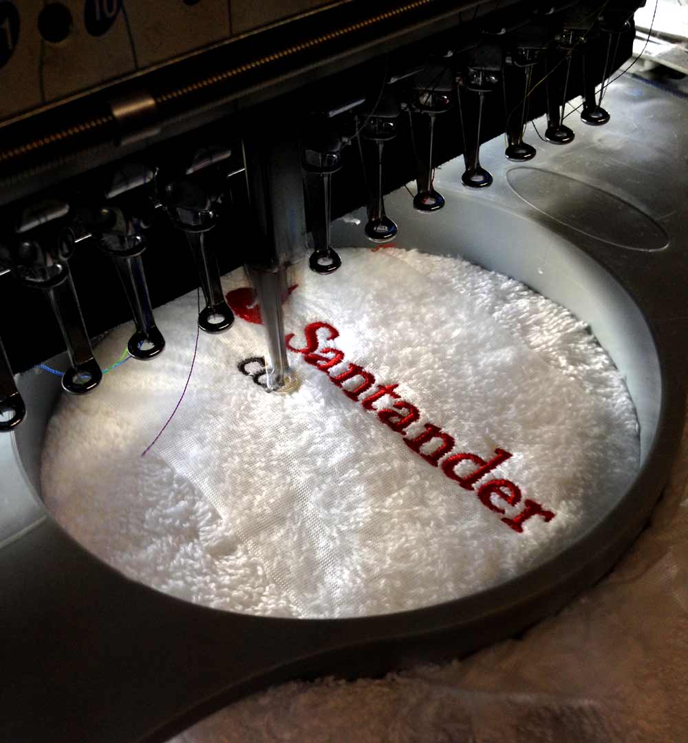 Embroidery machine sitiching a custom design towel