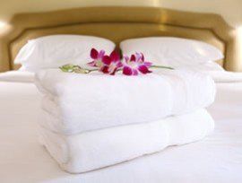 Bale of white luxury towels on hotel bed