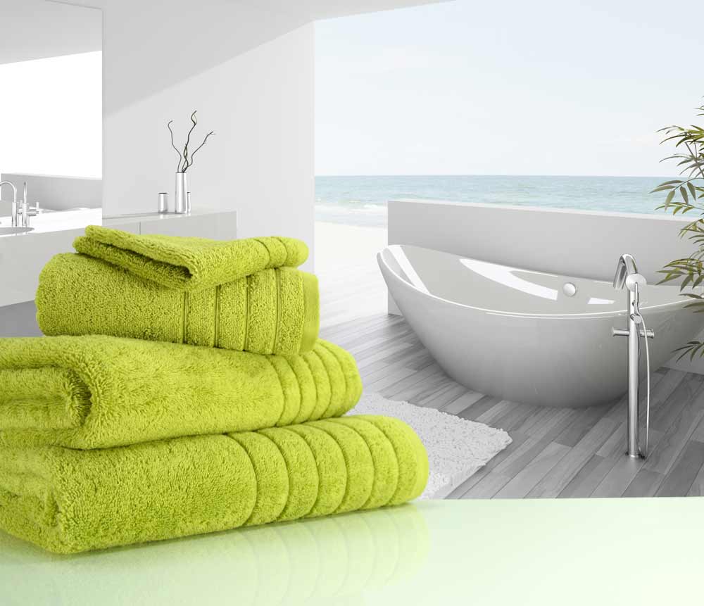 Folded sea grass coloured 650gsm luxury towels near a bathtub