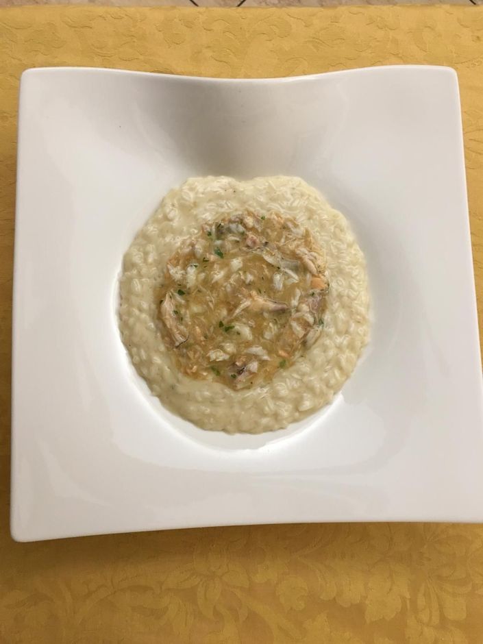 Piatto da dessert con tre delizie: palla di gelato, diamante di cioccolato e crostatina di frutta. Cosparso di zucchero a velo e scorza d'arancia.