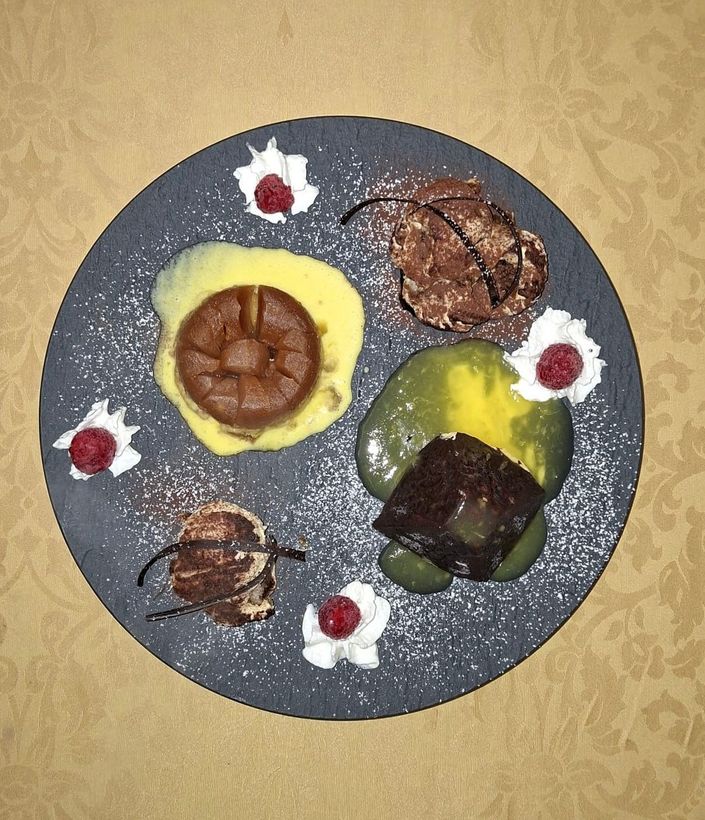 Piatto elegante con due cappelli di funghi, salsa gialla e guarnizione di foglie verdi.