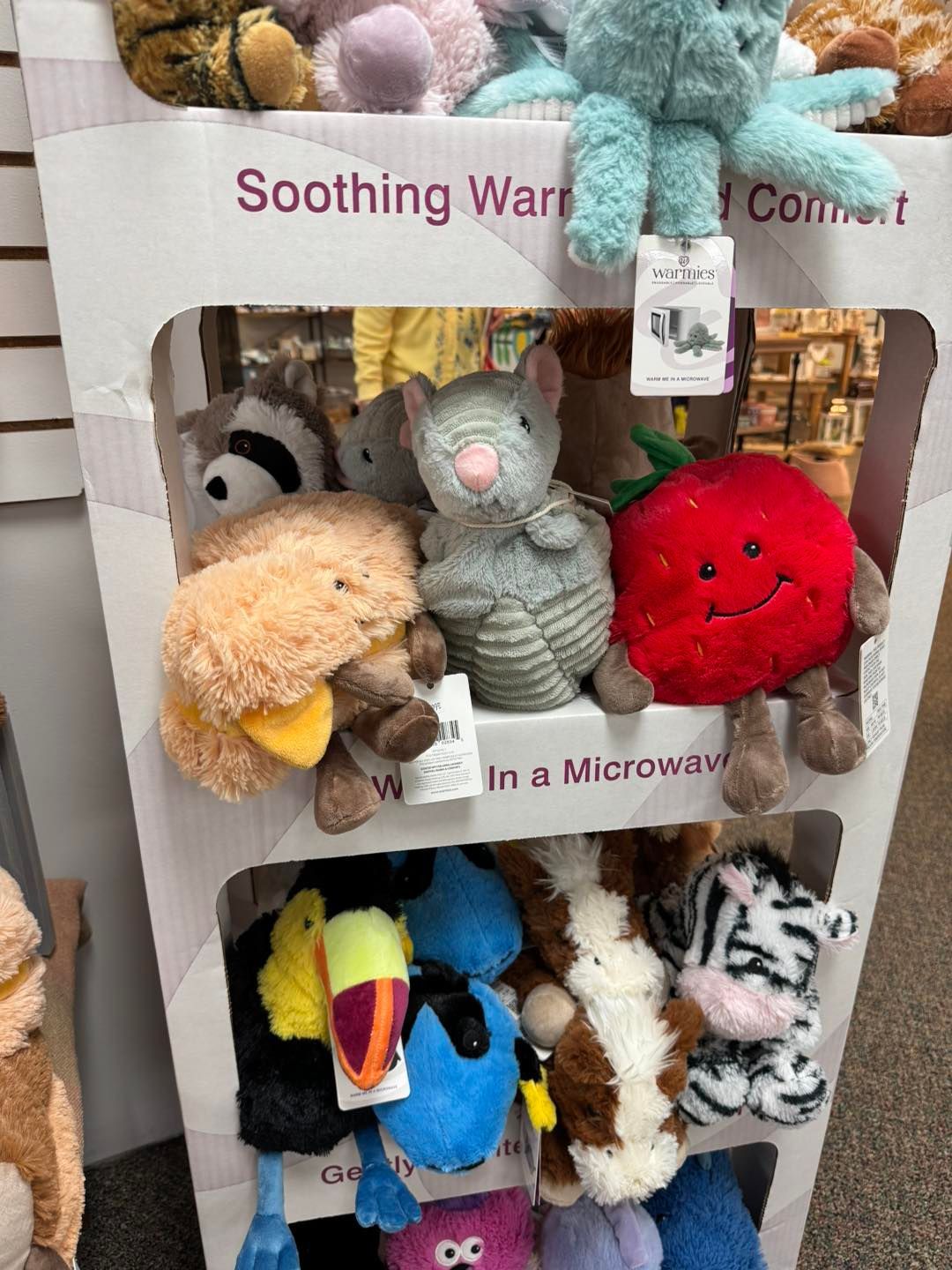 A display of stuffed animals in a microwave.