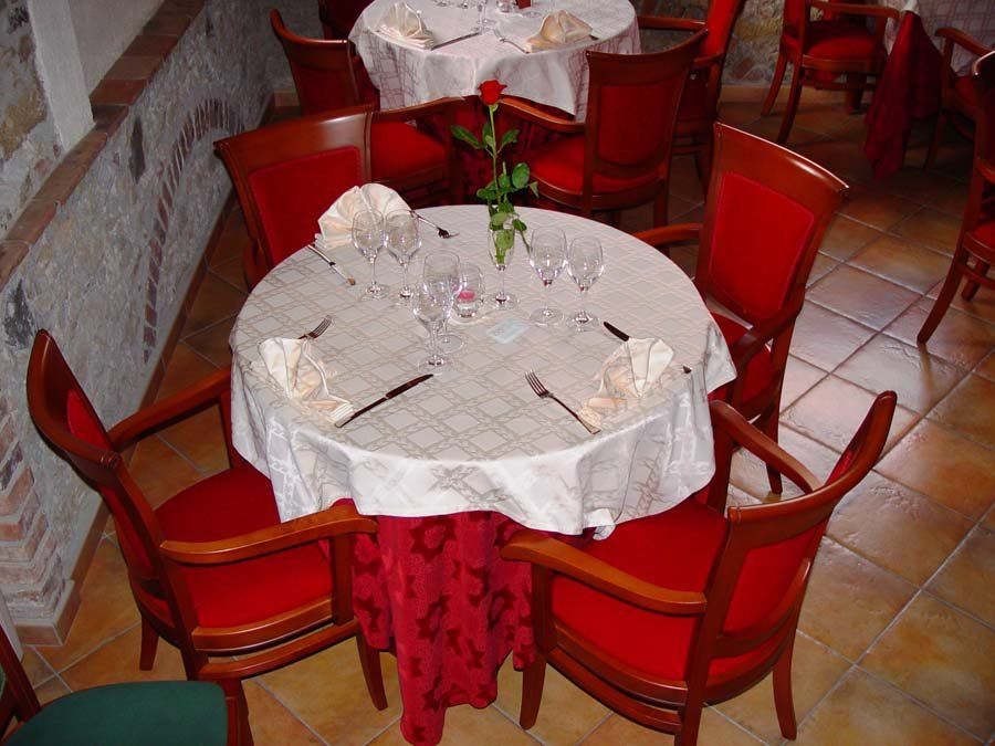 sala elegante con tavoli rotondi e sedie rosse