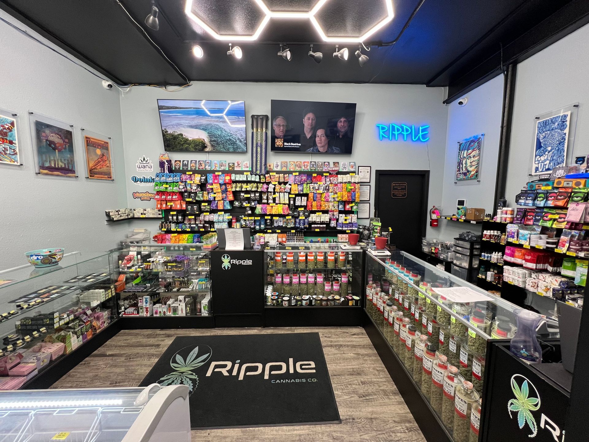 Interior of a cannabis retail store with displays, products, and a neon sign that reads 