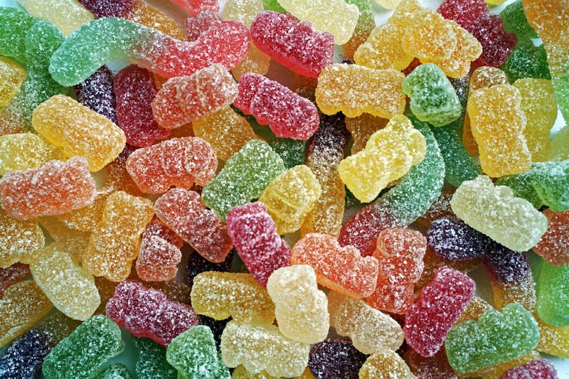 Close-up of assorted colorful, sugared gummy candies in various shapes and shades.