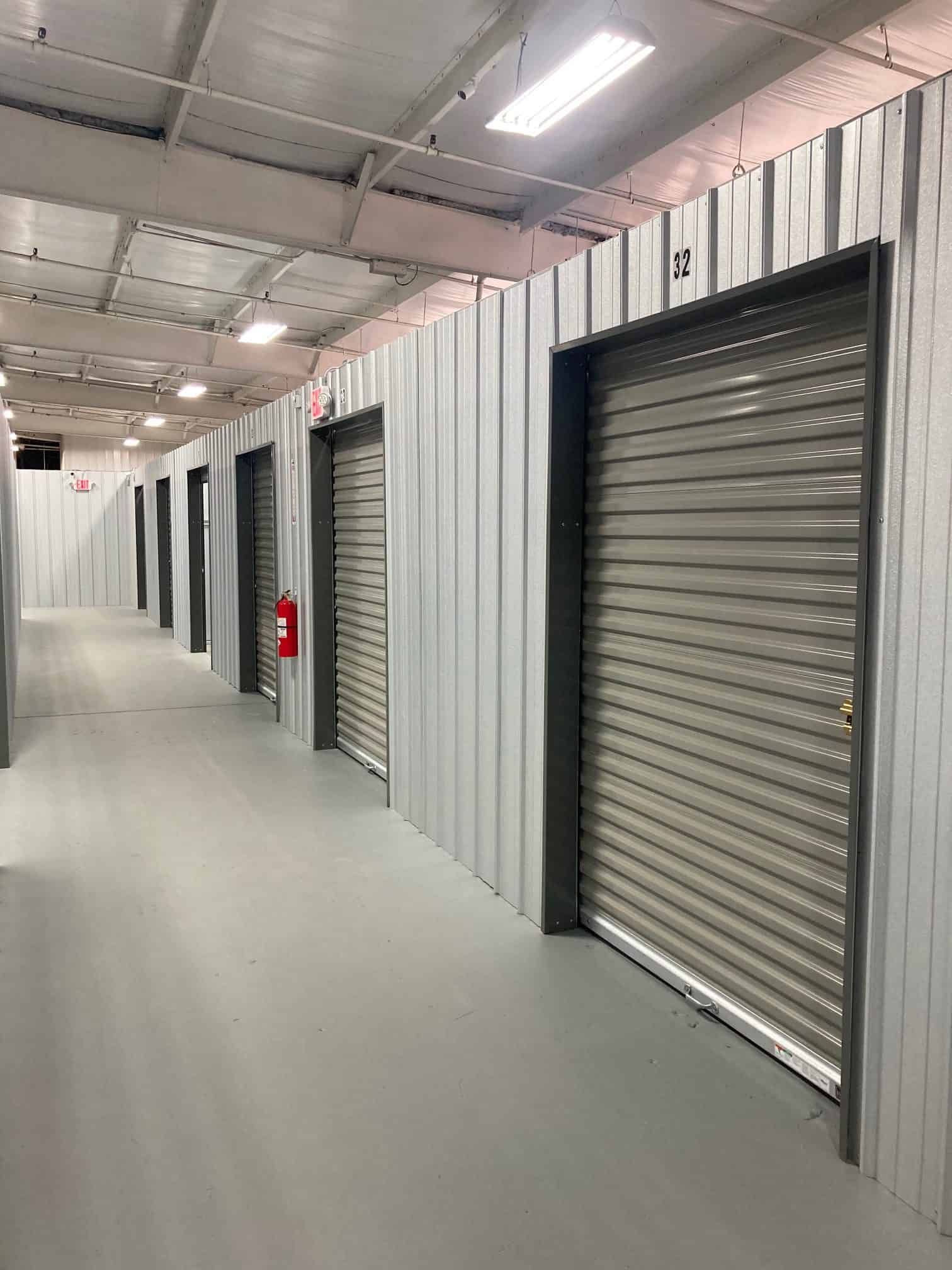 A row of storage units in a building with a fire extinguisher on the wall.