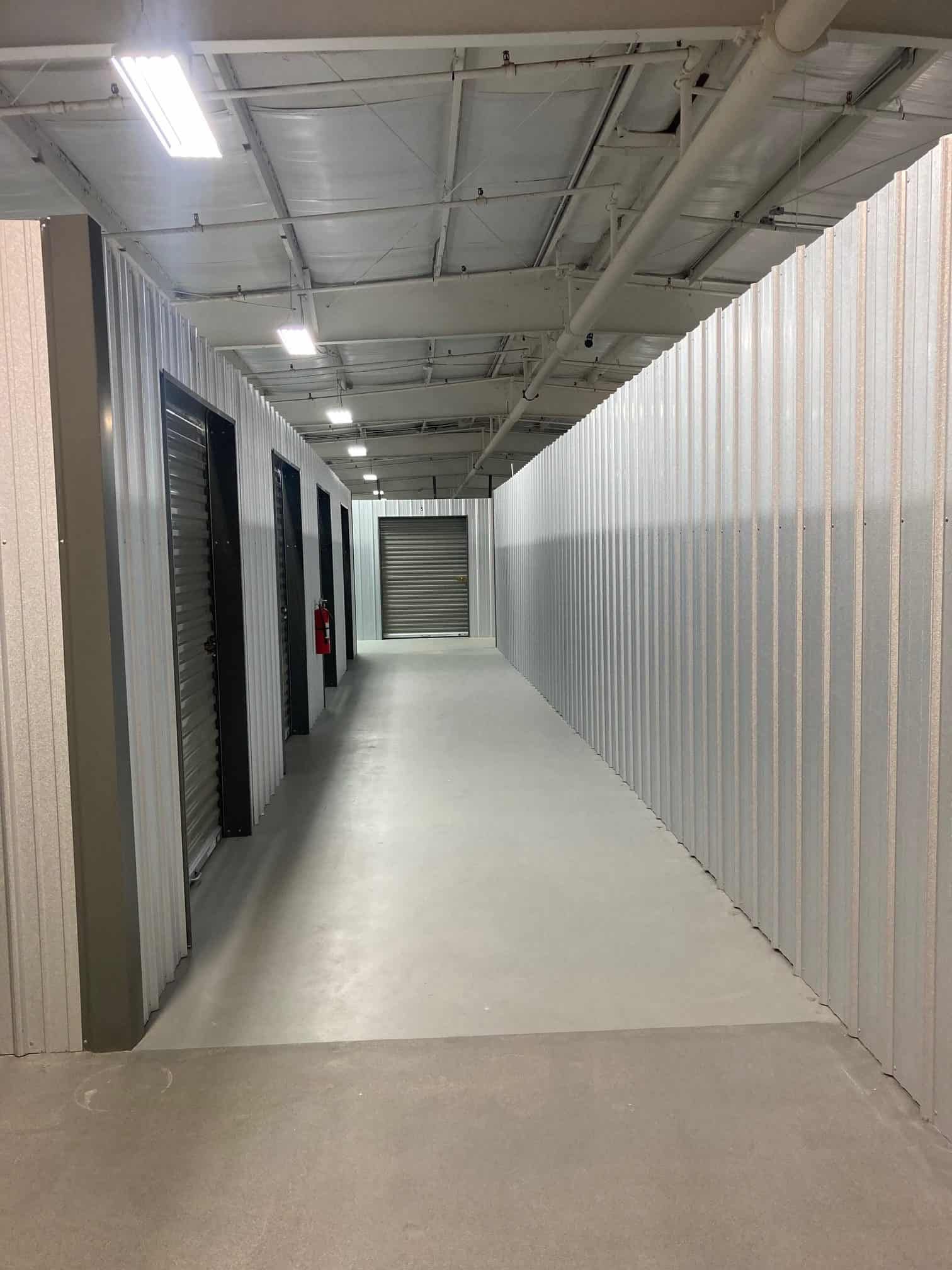 A long hallway with a lot of doors in a building.