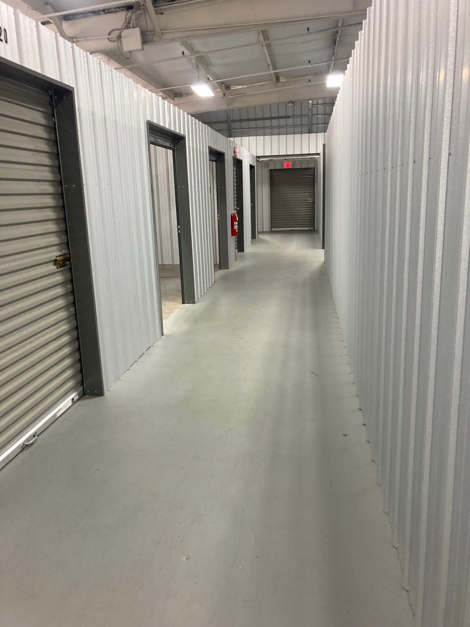 A long hallway filled with lots of storage units in a building.