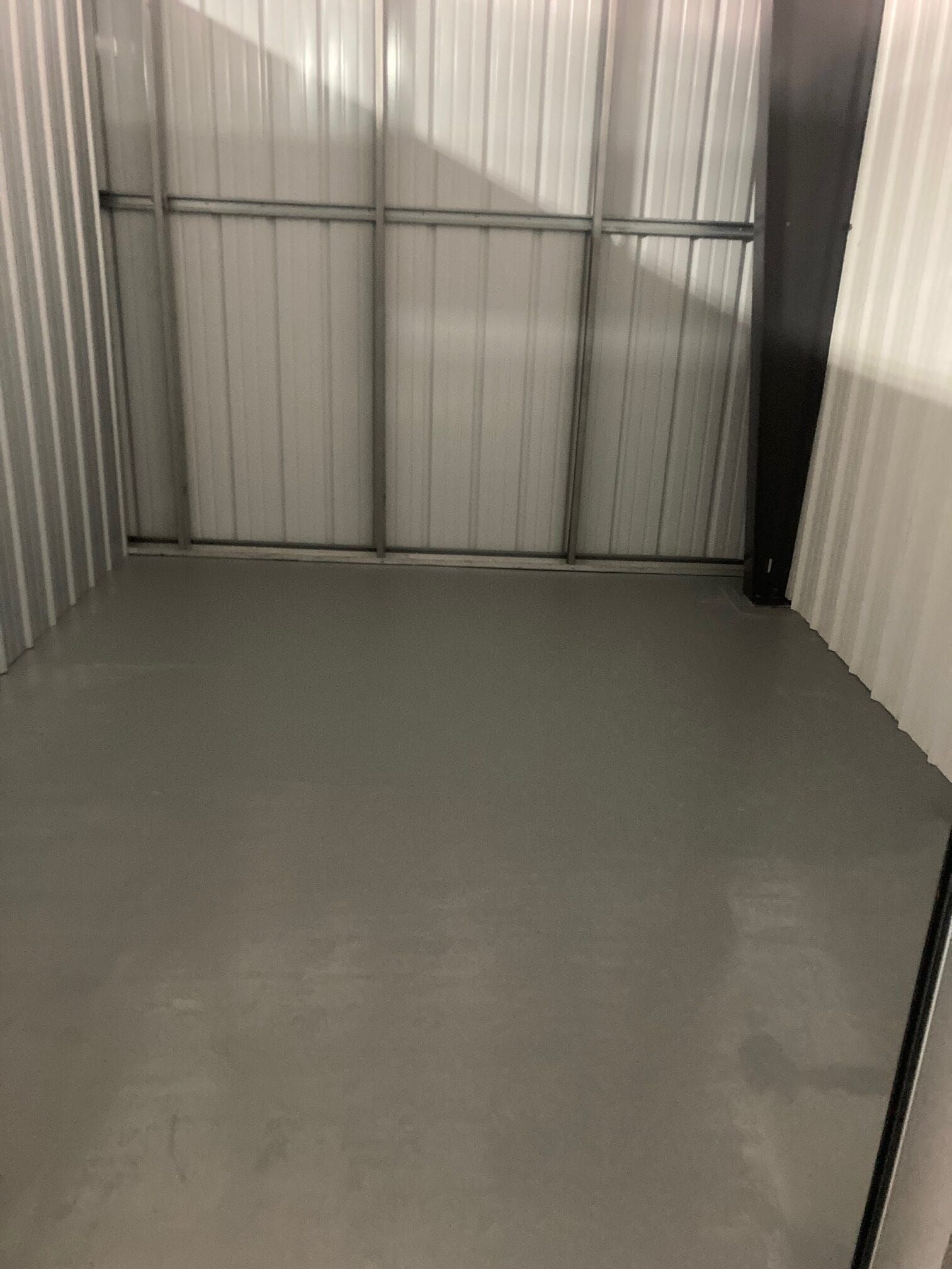 A small empty room with a gray floor and white walls.