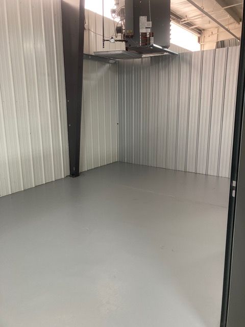 A long hallway with a red exit sign on the ceiling