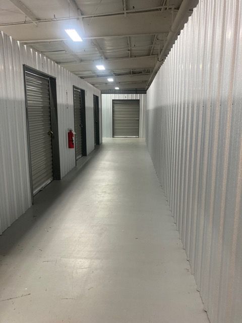 A stack of cardboard boxes on a dolly in front of a white brick wall.