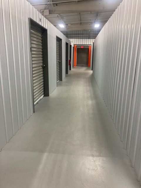 A man is holding a stack of cardboard boxes in a warehouse.