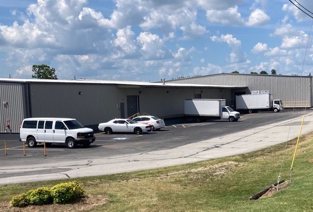 A warehouse filled with lots of cardboard boxes and pallets.
