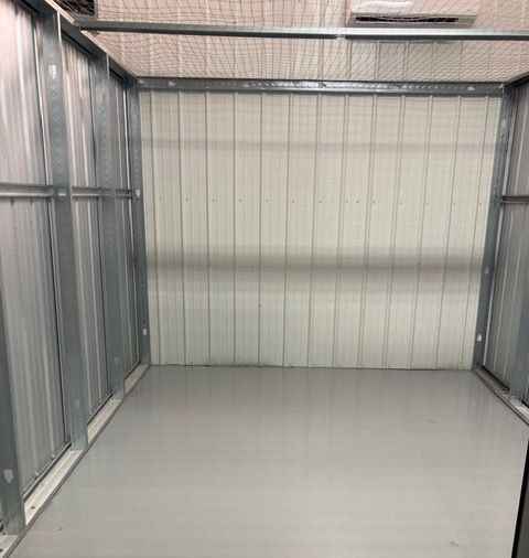 A long hallway with green doors in a building