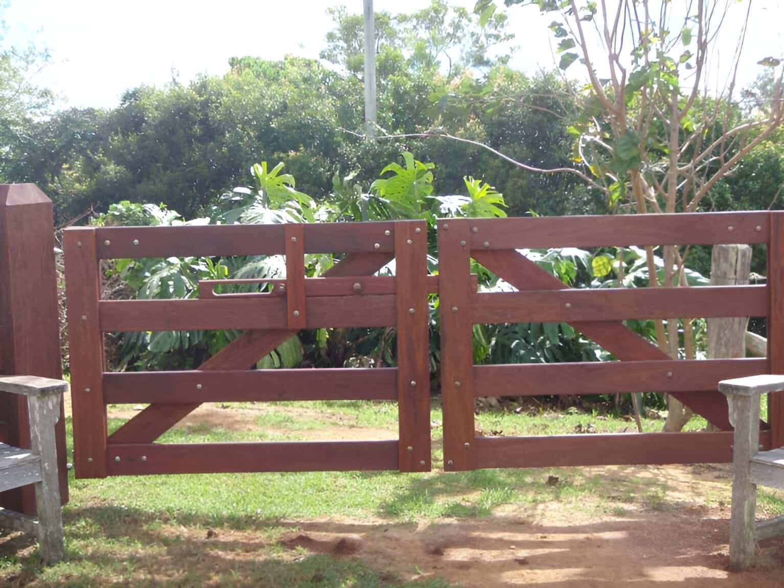 A Wooden Gate Is Open To A Lush Green Field — John Stark Fencing In Landsborough, QLD