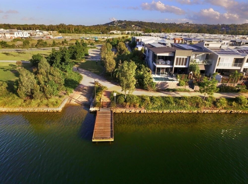 An Aerial View Of A House Next To A Body Of Water With A Dock — John Stark Fencing In Maroochydore Hinterland, QLD