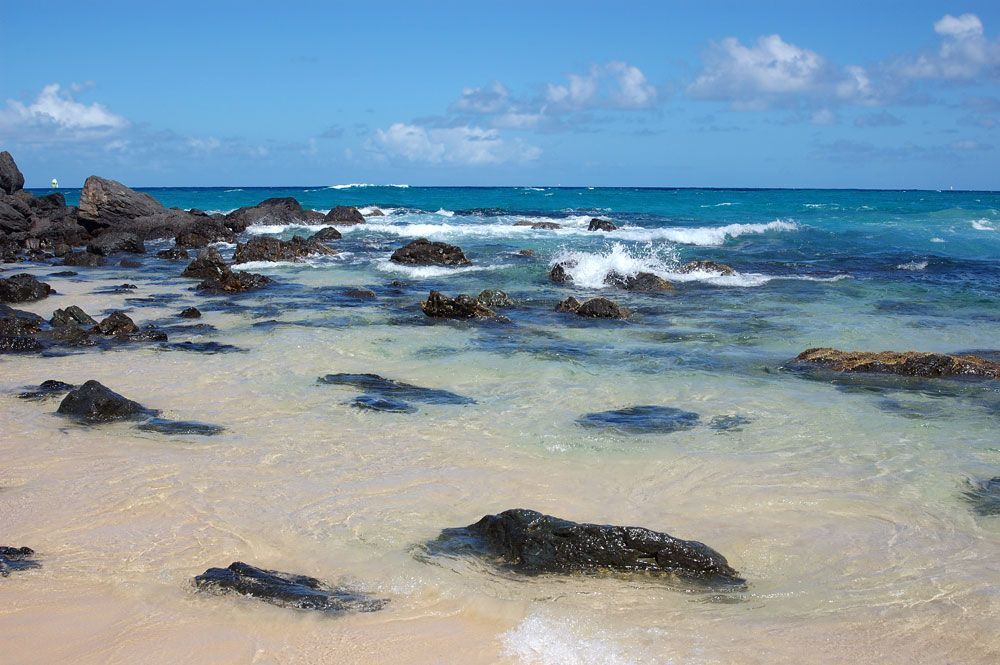 A Beach With Rocks In The Water And Waves Crashing On The Shore — John Stark Fencing In Nambour, QLD