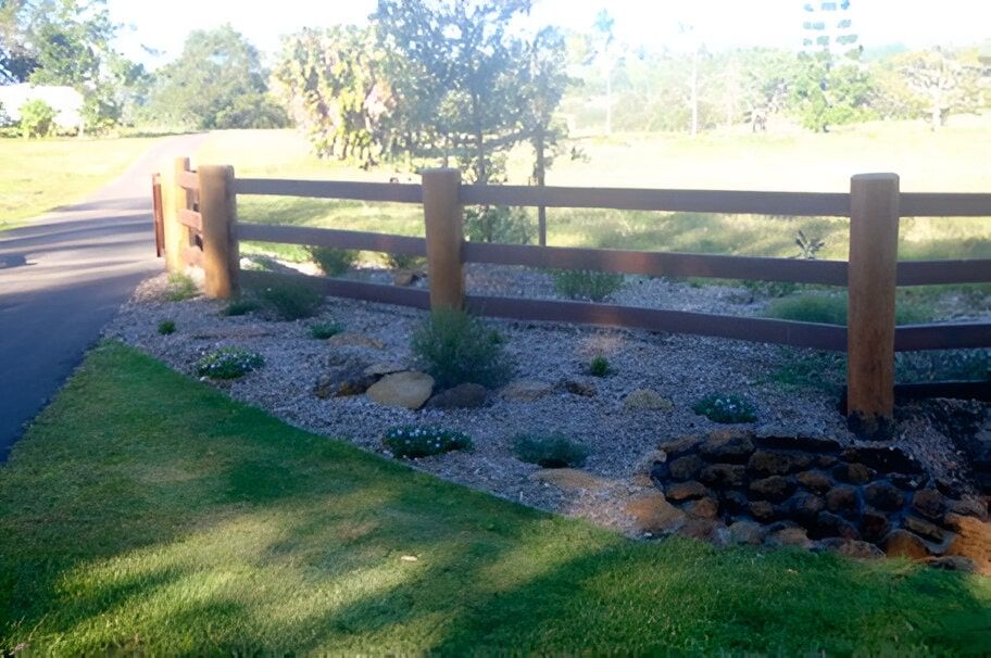 A Wooden Fence Is Surrounded By Rocks And Grass — John Stark Fencing In West Woombye, QLD